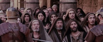 Movie still from “The Passion of the Christ” (2004), directed by Mel Gibson – A group of men and women wearing robes and hoods; Medium shot, High angle