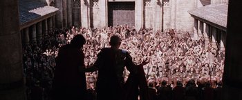 Movie still from “The Passion of the Christ” (2004), directed by Mel Gibson – A crowd of people gathered in front of a building; Extreme Wide shot, High angle