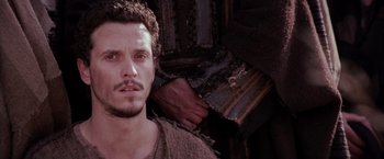 Movie still from “The Passion of the Christ” (2004), directed by Mel Gibson – A person holding a piece of wood; Close Up shot, Low angle