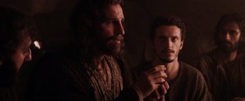 Movie still from “The Passion of the Christ” (2004), directed by Mel Gibson – A man with long hair and a beard is holding his hands together while a man with long hair and a beard is holding his hands together; Close Up shot, Over the shoulder angle