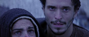 Movie still from “The Passion of the Christ” (2004), directed by Mel Gibson – A man and a woman are looking at the camera; Close Up shot, Low angle