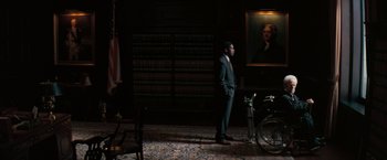 Movie still from “The Pelican Brief” (1993), directed by Alan J. Pakula – A man in a suit standing next to a bicycle; Wide shot, High angle