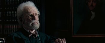 Movie still from “The Pelican Brief” (1993), directed by Alan J. Pakula – An old man with a bow tie sitting in a chair; Close Up shot, Low angle