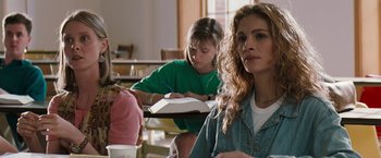 Movie still from “The Pelican Brief” (1993), directed by Alan J. Pakula – A group of people sitting in a classroom; Medium shot, Over the shoulder angle