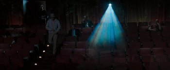 Movie still from “The Pelican Brief” (1993), directed by Alan J. Pakula – People are sitting in a movie theater at night; Wide shot, High angle
