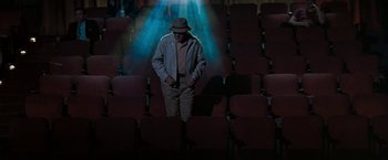 Movie still from “The Pelican Brief” (1993), directed by Alan J. Pakula – An old man standing in the middle of an empty theater; Wide shot, High angle