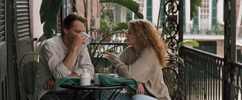 Movie still from “The Pelican Brief” (1993), directed by Alan J. Pakula – A man and a woman sitting at an outdoor table drinking coffee; Medium shot, Over the shoulder angle