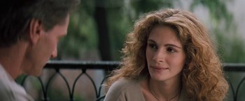 Movie still from “The Pelican Brief” (1993), directed by Alan J. Pakula – A person sitting on a bench; Close Up shot, Over the shoulder angle