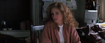 Movie still from “The Pelican Brief” (1993), directed by Alan J. Pakula – A woman sitting on top of a wooden bench; Close Up shot, Over the shoulder angle
