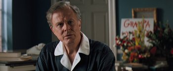 Movie still from “The Pelican Brief” (1993), directed by Alan J. Pakula – An older man in a black shirt is looking at the camera; Close Up shot, Over the shoulder angle