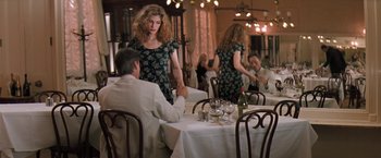 Movie still from “The Pelican Brief” (1993), directed by Alan J. Pakula – A woman is standing at a table in front of a man; Wide shot, Over the shoulder angle