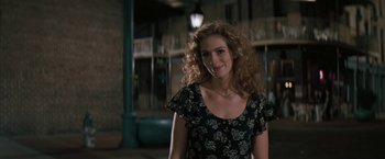Movie still from “The Pelican Brief” (1993), directed by Alan J. Pakula – A woman with curly hair standing in front of a lamp post; Medium shot, Over the shoulder angle