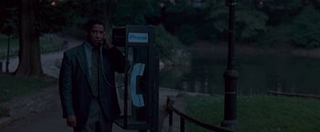Movie still from “The Pelican Brief” (1993), directed by Alan J. Pakula – A man talking on a phone next to a pond; Medium shot, High angle