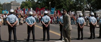 Movie still from “The Pelican Brief” (1993), directed by Alan J. Pakula – A group of people protesting on a street; Wide shot, High angle