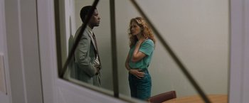 Movie still from “The Pelican Brief” (1993), directed by Alan J. Pakula – A man and a woman standing next to each other in front of a mirror; Medium shot, Over the shoulder angle