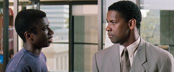 Movie still from “The Pelican Brief” (1993), directed by Alan J. Pakula – Two men in business suits talking to each other; Close Up shot, Over the shoulder angle