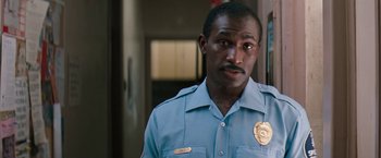 Movie still from “The Pelican Brief” (1993), directed by Alan J. Pakula – A man in a blue shirt is standing in front of a door; Close Up shot, Low angle