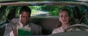 Movie still from “The Pelican Brief” (1993), directed by Alan J. Pakula – A man and a woman sitting in the back of a car; Medium shot, Over the shoulder angle
