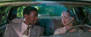 Movie still from “The Pelican Brief” (1993), directed by Alan J. Pakula – A man and a woman sitting in the back of a car; Close Up shot, Over the shoulder angle