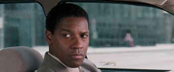 Movie still from “The Pelican Brief” (1993), directed by Alan J. Pakula – A person wearing a suit in a car; Close Up shot, Over the shoulder angle