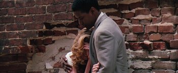 Movie still from “The Pelican Brief” (1993), directed by Alan J. Pakula – A man and a woman kissing in front of a brick wall; Close Up shot, Low angle
