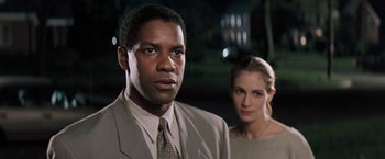 Movie still from “The Pelican Brief” (1993), directed by Alan J. Pakula – A man and a woman standing next to each other; Close Up shot, Over the shoulder angle