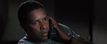 Movie still from “The Pelican Brief” (1993), directed by Alan J. Pakula – A man talking on a phone while sitting down; Close Up shot, Low angle