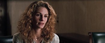 Movie still from “The Pelican Brief” (1993), directed by Alan J. Pakula – A beautiful woman with curly hair and a white shirt; Close Up shot, Over the shoulder angle