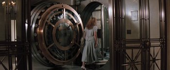 Movie still from “The Pelican Brief” (1993), directed by Alan J. Pakula – A woman in a white dress standing in front of a large metal door; Wide shot, Low angle
