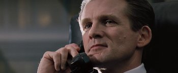 Movie still from “The Pelican Brief” (1993), directed by Alan J. Pakula – An older man talking on a phone while wearing a suit; Close Up shot, Low angle
