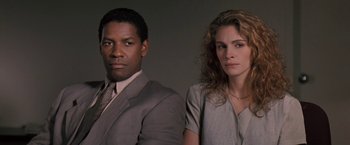 Movie still from “The Pelican Brief” (1993), directed by Alan J. Pakula – A man and a woman standing next to each other; Close Up shot, Low angle