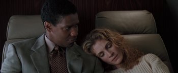 Movie still from “The Pelican Brief” (1993), directed by Alan J. Pakula – A man and a woman sitting next to each other on a couch; Close Up shot, High angle