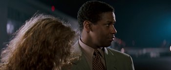 Movie still from “The Pelican Brief” (1993), directed by Alan J. Pakula – A person wearing a suit and tie; Close Up shot, Over the shoulder angle