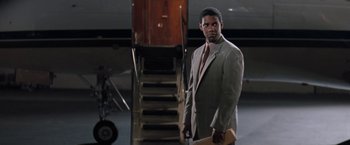 Movie still from “The Pelican Brief” (1993), directed by Alan J. Pakula – A man standing in front of an airplane; Medium shot, Low angle