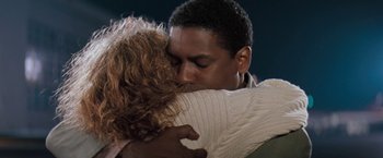 Movie still from “The Pelican Brief” (1993), directed by Alan J. Pakula – A man and a woman hugging each other in front of a dark background; Close Up shot, Low angle