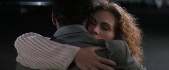 Movie still from “The Pelican Brief” (1993), directed by Alan J. Pakula – A man and a woman hugging each other in a car; Close Up shot, Over the shoulder angle