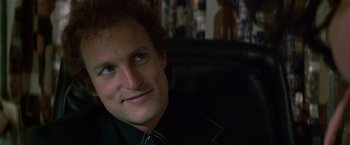 Movie still from “The People vs. Larry Flynt” (1996), directed by Milos Forman – A person wearing a black shirt and smiling; Close Up shot, Over the shoulder angle
