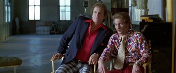Movie still from “The People vs. Larry Flynt” (1996), directed by Milos Forman – A man sitting next to another man in a chair; Medium shot, Low angle