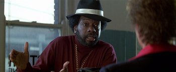 Movie still from “The People vs. Larry Flynt” (1996), directed by Milos Forman – A man in a black hat is talking to someone; Close Up shot, Over the shoulder angle