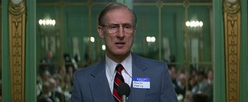 Movie still from “The People vs. Larry Flynt” (1996), directed by Milos Forman – An older man wearing a blue suit and a name tag; Close Up shot, Low angle