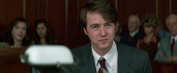 Movie still from “The People vs. Larry Flynt” (1996), directed by Milos Forman – A man in a gray suit and a red tie; Close Up shot, Over the shoulder angle