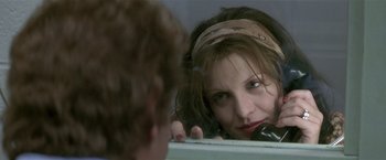 Movie still from “The People vs. Larry Flynt” (1996), directed by Milos Forman – A woman looking in the mirror while talking on the phone; Close Up shot, Over the shoulder angle