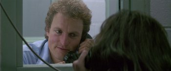 Movie still from “The People vs. Larry Flynt” (1996), directed by Milos Forman – A man with curly hair is talking on a phone; Close Up shot, Over the shoulder angle