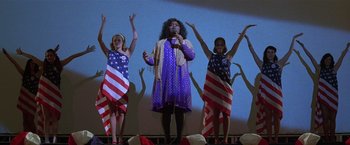 Movie still from “The People vs. Larry Flynt” (1996), directed by Milos Forman – A group of people standing on a stage with an american flag on them; Medium shot, Low angle