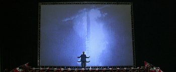 Movie still from “The People vs. Larry Flynt” (1996), directed by Milos Forman – A man standing in front of a large screen; Extreme Wide shot, Low angle