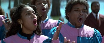 Movie still from “The People vs. Larry Flynt” (1996), directed by Milos Forman – A group of young people singing in a park; Close Up shot, Low angle