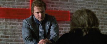 Movie still from “The People vs. Larry Flynt” (1996), directed by Milos Forman – A man wearing a suit and tie sitting at a table; Close Up shot, Over the shoulder angle