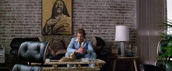 Movie still from “The People vs. Larry Flynt” (1996), directed by Milos Forman – A man sitting on top of a couch in a living room; Wide shot, High angle