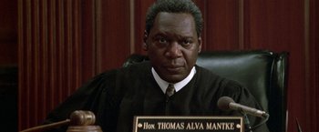Movie still from “The People vs. Larry Flynt” (1996), directed by Milos Forman – A man wearing a judge's robe and holding a plaque; Close Up shot, Low angle