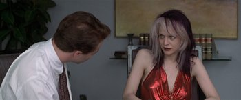 Movie still from “The People vs. Larry Flynt” (1996), directed by Milos Forman – A woman in a red dress sitting in front of a man; Medium shot, Over the shoulder angle